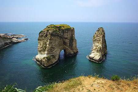 photo of rock formation on body of water during daytime thumbnail