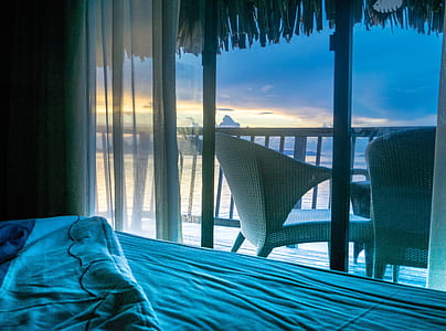 two brown wicker armchairs on terrace near seashore thumbnail