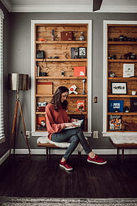 woman sitting on chair while reading book thumbnail