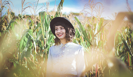 woman standing on corn field during daytime thumbnail