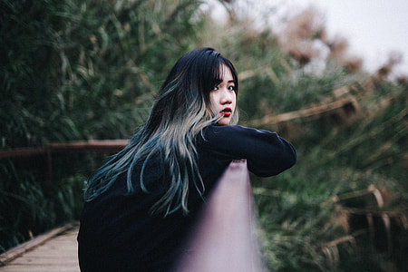 woman on fence near tree thumbnail