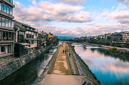 Group of People Walking Between Body of Water thumbnail