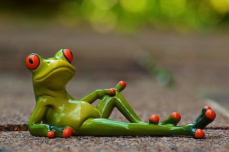 green ceramic frog figurine lying on gray concrete road in closed up photography thumbnail