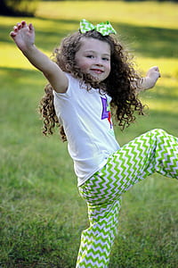 girl in white shirt and green chevron pants doing dance moves during daytime thumbnail