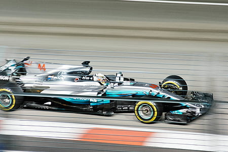 timelapse photography of blue and black formula 1 racing on road thumbnail