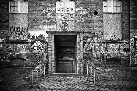 graffiti on brick wall in grayscale photography thumbnail