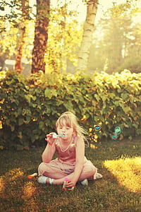girl wearing brown and white tank top sitting on green grass photography thumbnail