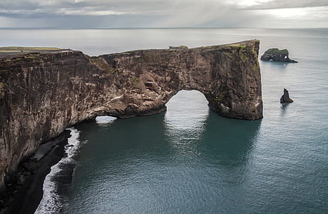 brown rock formation on body of water thumbnail