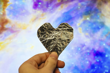 person holding silver heart paper decor thumbnail