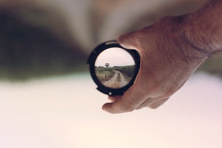 selective focus photography of person holding telescope thumbnail