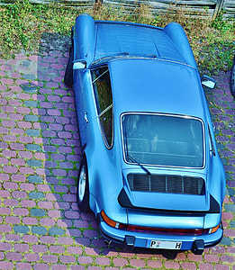 parked coupe near grasses and fence thumbnail