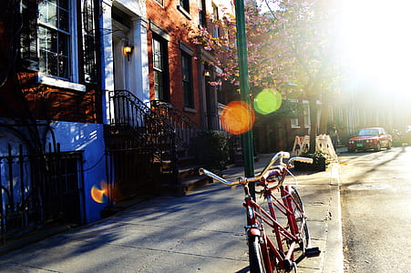 red tandem bicycle parked next to green pole outdoor thumbnail