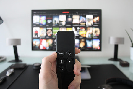 Man using Apple Television with remote control for movies thumbnail