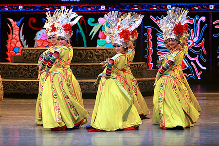 women in yellow long-sleeved dress dancing on stage thumbnail