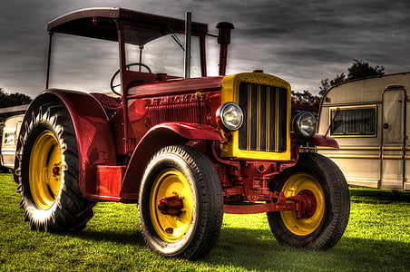 red and yellow tractor placed near travel trailer thumbnail