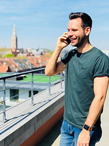 Man Wearing Black Crew-neck Shirt Holding Mobile Phone thumbnail