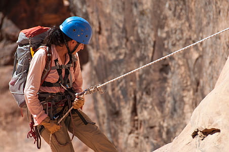 person wearing gray hiking backpack and blue helmet thumbnail