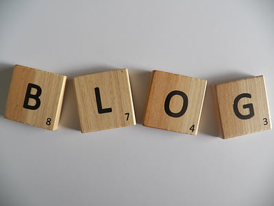 four brown wooden B, L, O, G rummikub pieces on top of white surface thumbnail