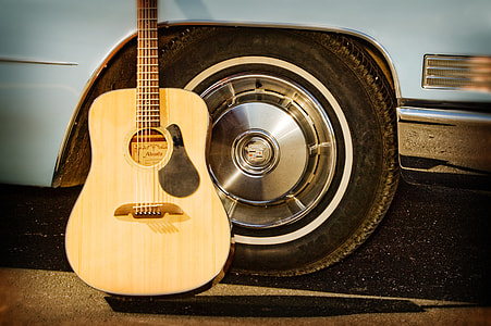 brown dreadnought acoustic guitar on white car thumbnail