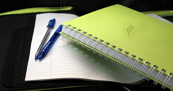 green book beside two pens thumbnail