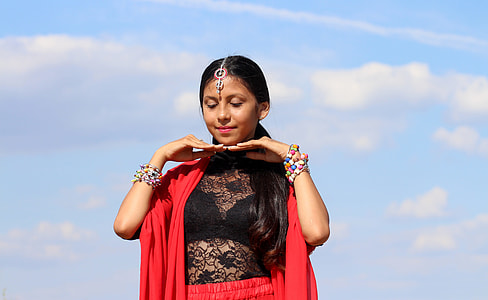 smiling woman in black floral mesh illusion top wearing red scarf during daytime thumbnail