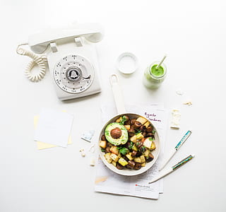 white rotary phone near food product on white printer papers and pens thumbnail