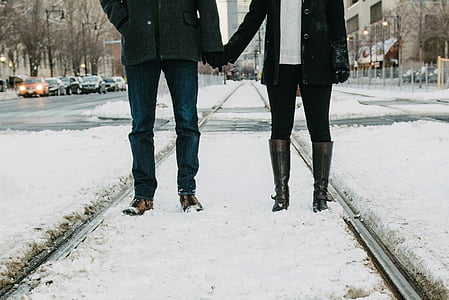 man holding woman wearing jackets standing on railroad during winter thumbnail