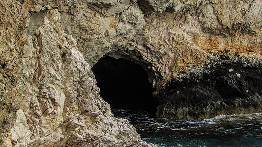 cave near body of water thumbnail