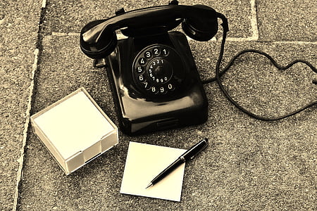 black rotary phone on black surface thumbnail