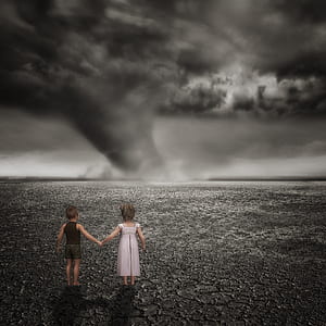 boy and girl standing on gray surface near hurricane thumbnail