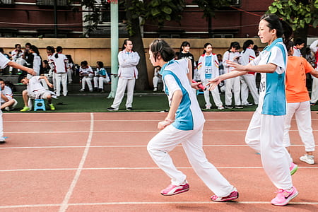 girls playing on brown field during daytime thumbnail