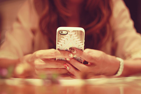 woman holding iPhone with white and brown case thumbnail