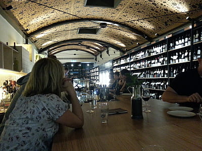 people sitting by the table inside bar with ceiling lights on thumbnail