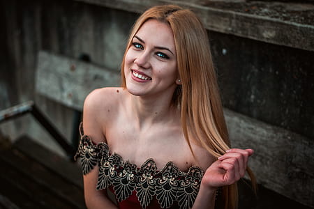 woman smiling while holding her hair thumbnail