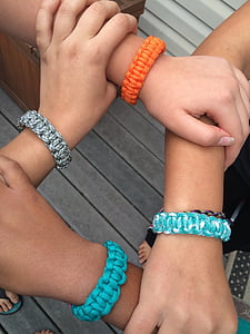 three person touching wrist forming square with survival bracelets thumbnail