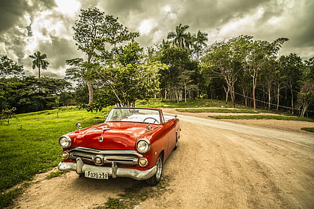 red convertible coupe on road under white sky thumbnail