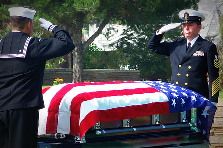 two man saluting in front of coffins thumbnail