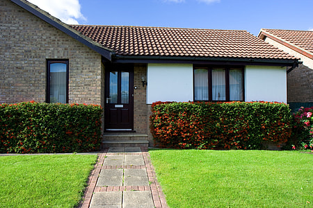 white and gray concrete bungalow house beside green bush plant during daytime thumbnail