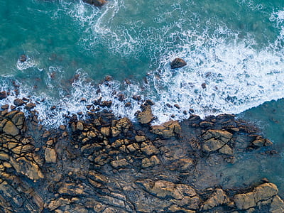 body of water near rocks at daytime thumbnail