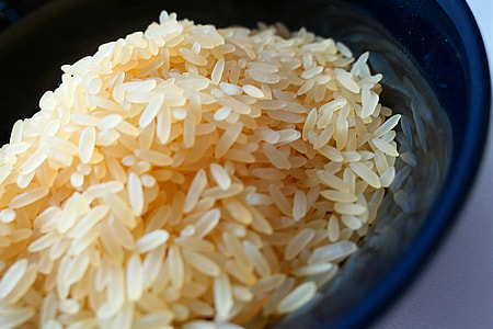 yellow rice grains on blue ceramic bowl thumbnail