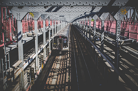 train on railway near metal poles during daytime thumbnail