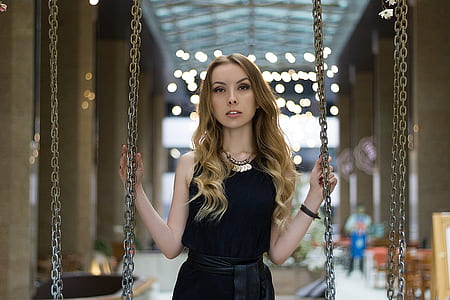 black sleeveless dress woman holding chains thumbnail