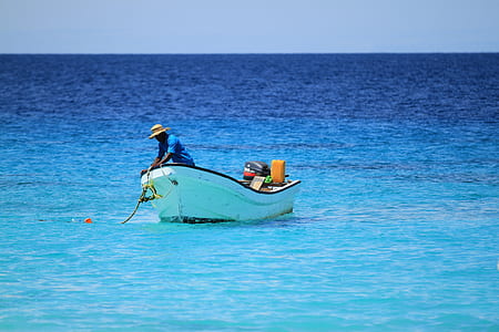 man standing on white boat during day time thumbnail