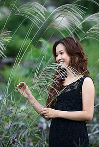 woman wearing black lace sleeveless dress beside plants thumbnail