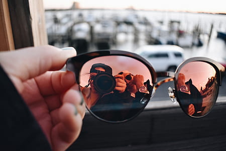 Close-Up Photography of a Person Holding Sunglasses thumbnail