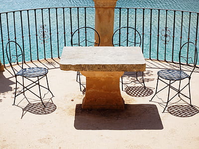 rectangular brown concrete table and four black chairs thumbnail