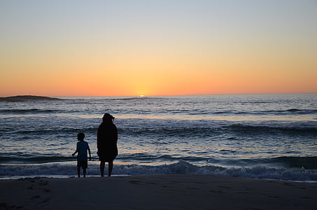 silhouette of child and person standing beside seashore thumbnail