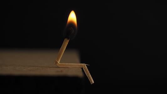 Lighted Matchstick on Brown Wooden Surface thumbnail