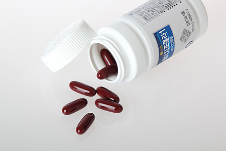 brown medication pill in white plastic container thumbnail