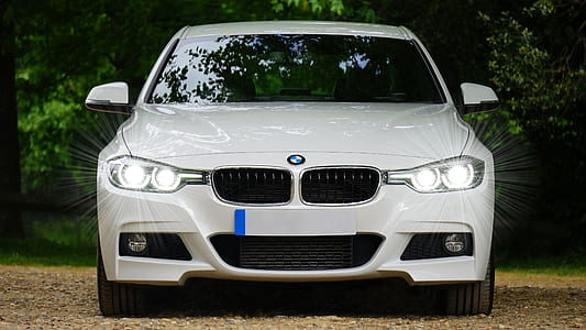 white BMW 5 series with headlights turned on at daytime thumbnail